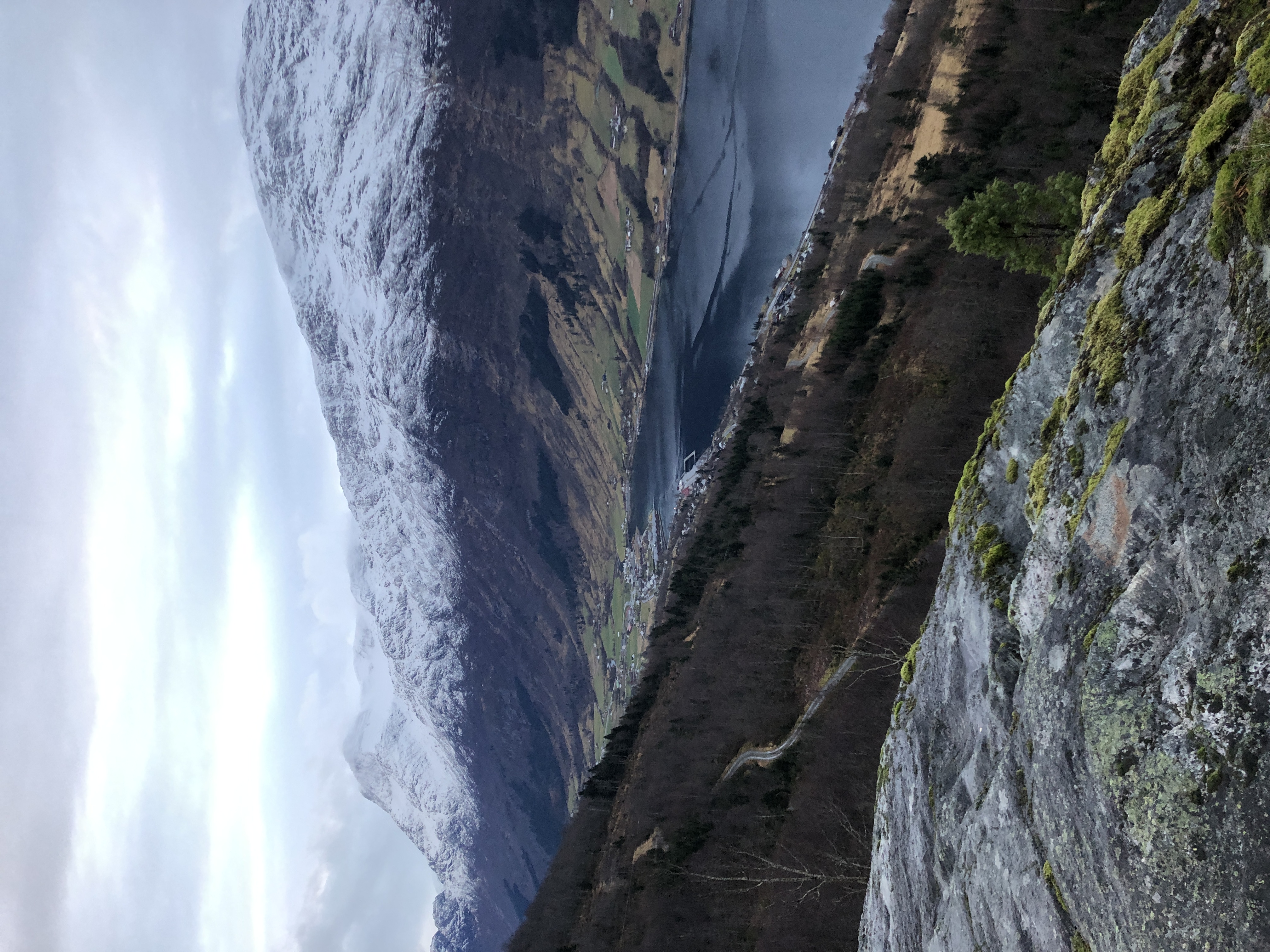 Stand-up paddleboarder på det turkise Lovatnet nær Olden, Norge, omgitt av dramatiske brefjell og grønne dalsider