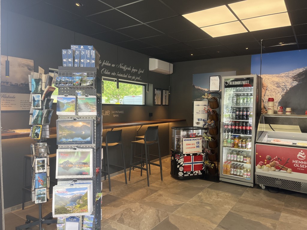 Innsiden av Stabukk kafé i Olden. Bilder av Olden på veggen, norske postkort og innendørsservering.