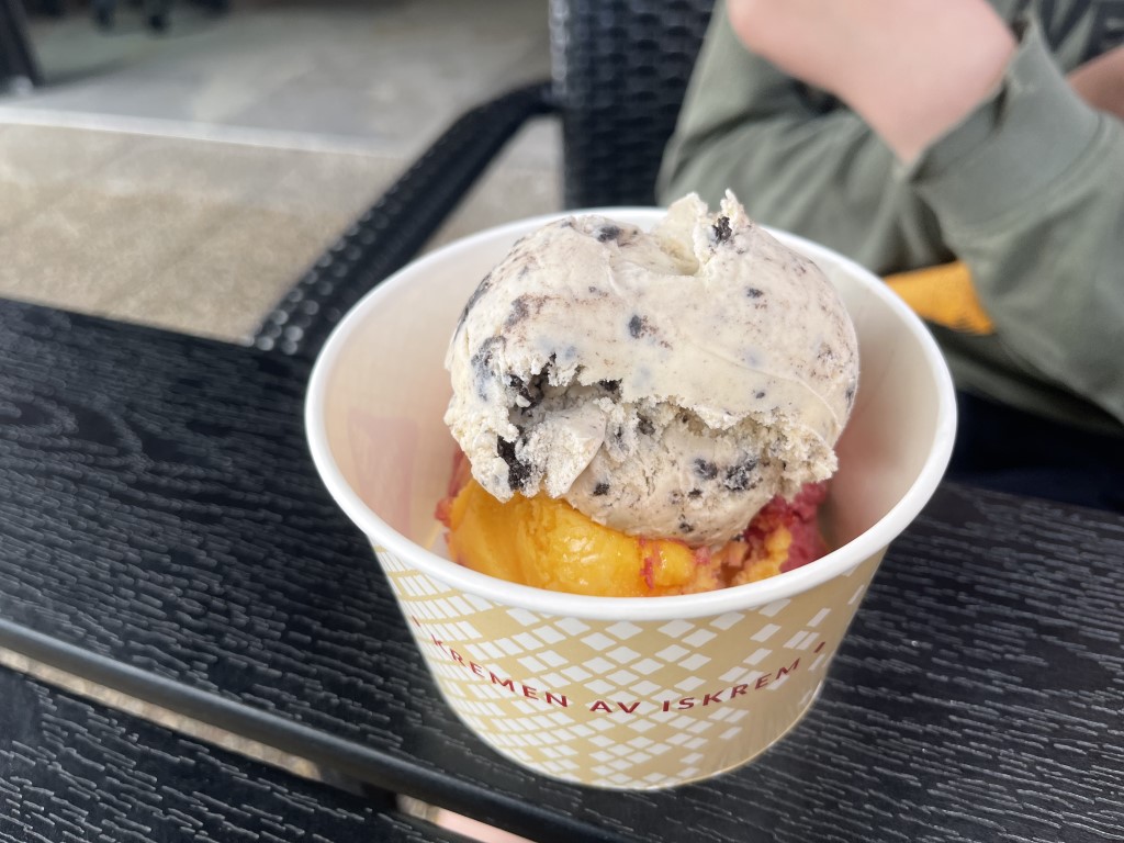 En iskremkopp fra Stabukk som inneholder en kule rød og oransje sorbet og oppå en kule kjeks og krem.