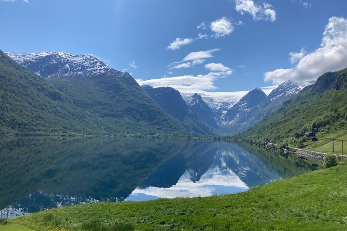 Perfekt speilbilde av Jostedalsbreen og fjellene i Oldevatnet, sett fra badstueområdet i Olden, Norge