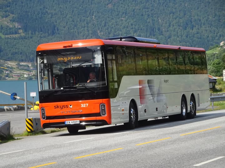 Buss som køyrer gjennom det vakre landskapet i Olden, Noreg