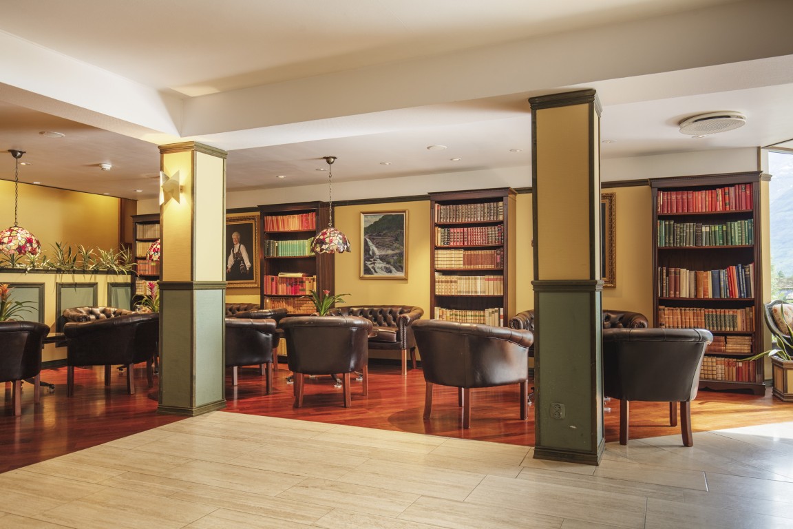 En rustikk og koselig foajé. Det innbydende området på Olden Fjordhotel, med en stor klassisk bibliotek.
