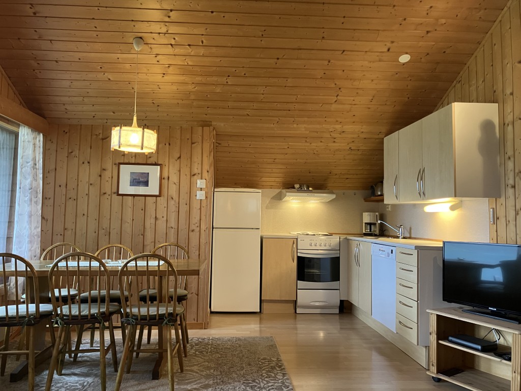 Innsiden av feriehuset Flåten. En sittegruppe til venstre, med et fullt utstyrt kjøkken til høyre.