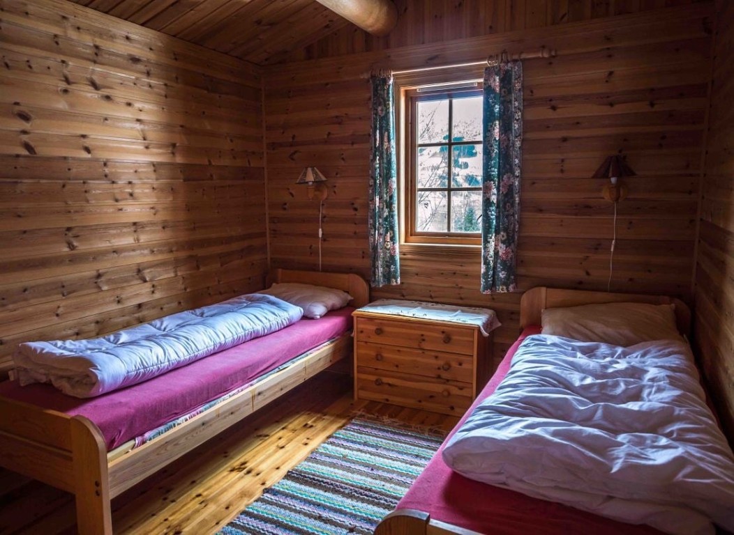 Tomannsrom i en koselig norsk feriehytte i Olden, med trevegger, furusenger og snødekt fjordutsikt fra vinduet