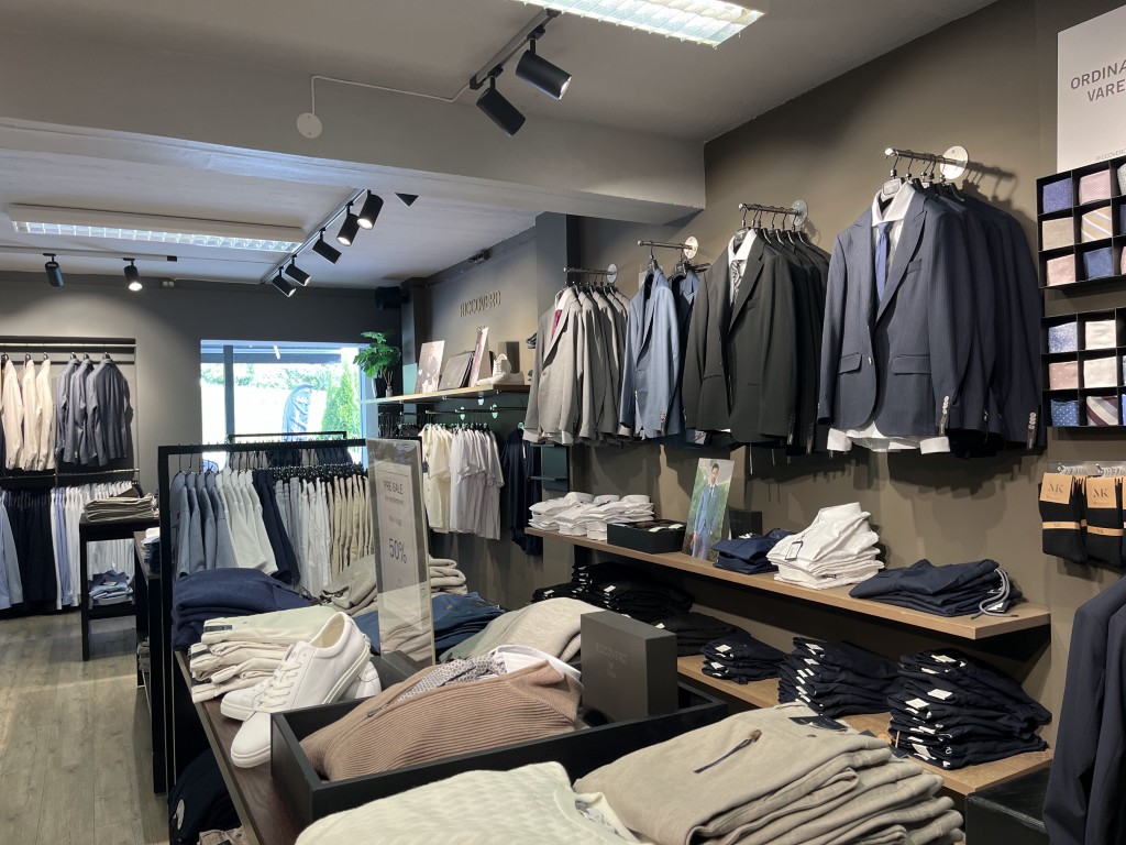 Riccovero herreklæravdeling i Olden som viser dresser, skjorter og foldede strikkeplagg – norsk kvalitetsmoteshopping i fjordene