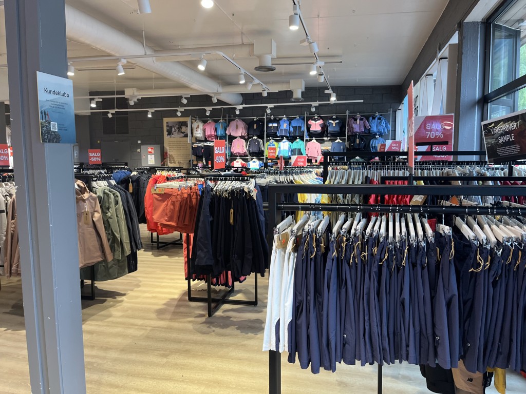 Interiør av Skogstad Outlet i Olden med stort utvalg av rabatterte friluftsklær, jakker, shorts og barneutstyr med opptil 70 % rabatt