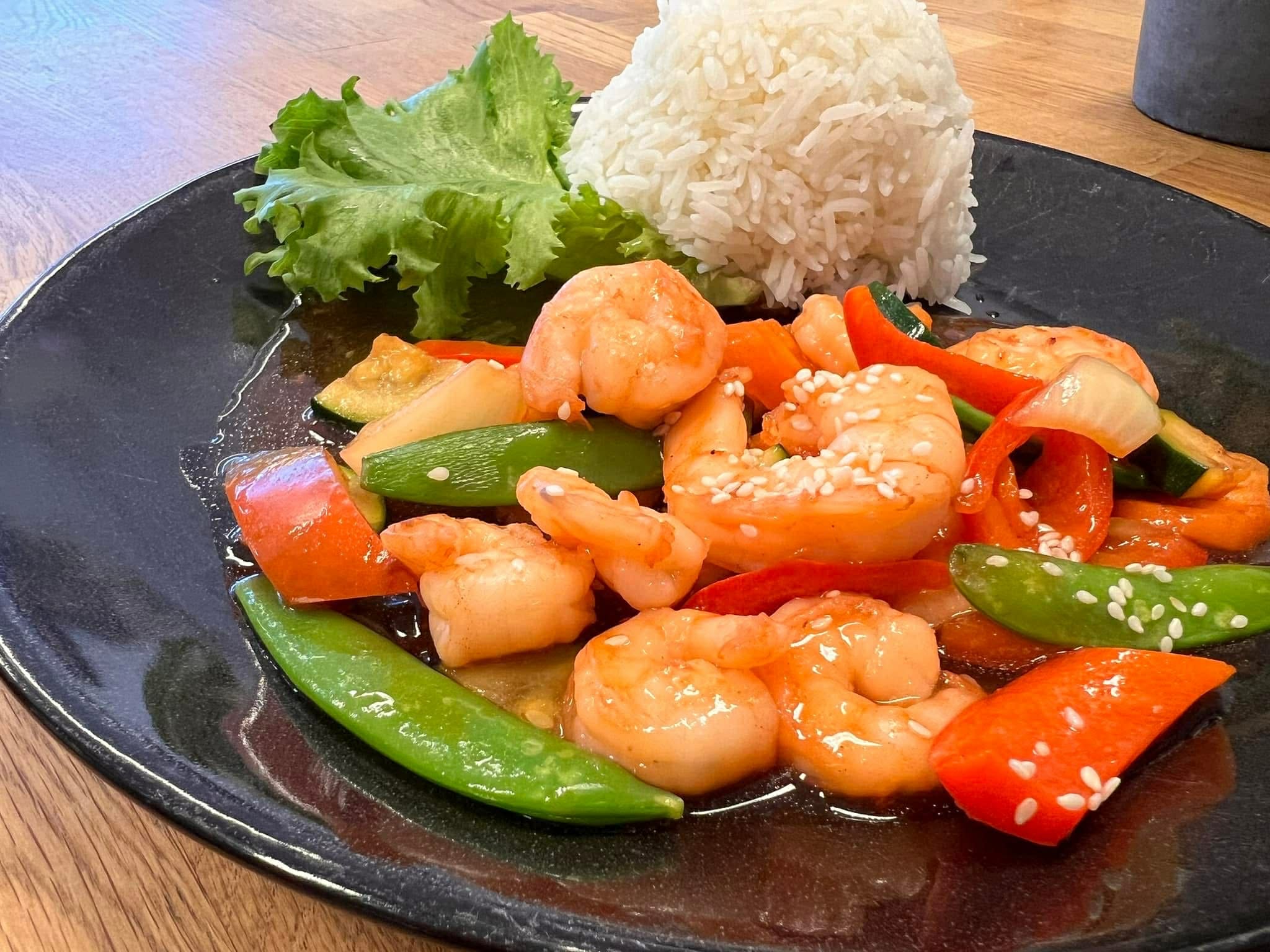 Wok med sesamreker, sukkererter, rød paprika og dampet ris servert på Sunde asiatiske restaurant i Olden