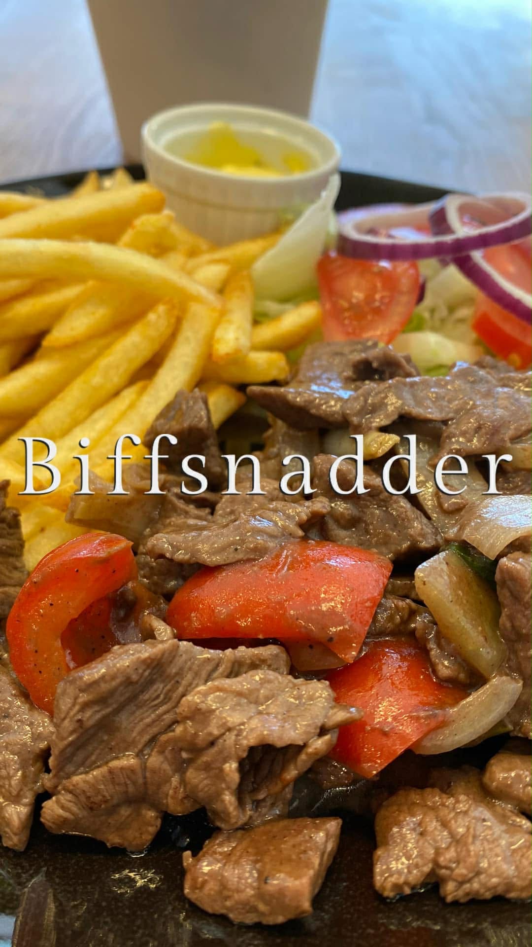 Biffsnadder – norske biffstrimler med tomat, løk, salat og pommes frites servert på Sunde restaurant i Olden, Norge