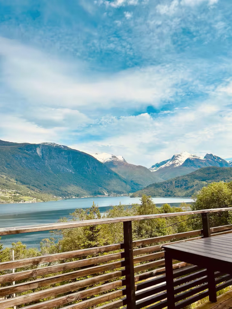 Fantastisk panoramautsikt over fjorden og fjellene fra terrassen på Vangberg gjestehus i Olden, Norge, med utsikt over Nordfjorden og snødekte topper